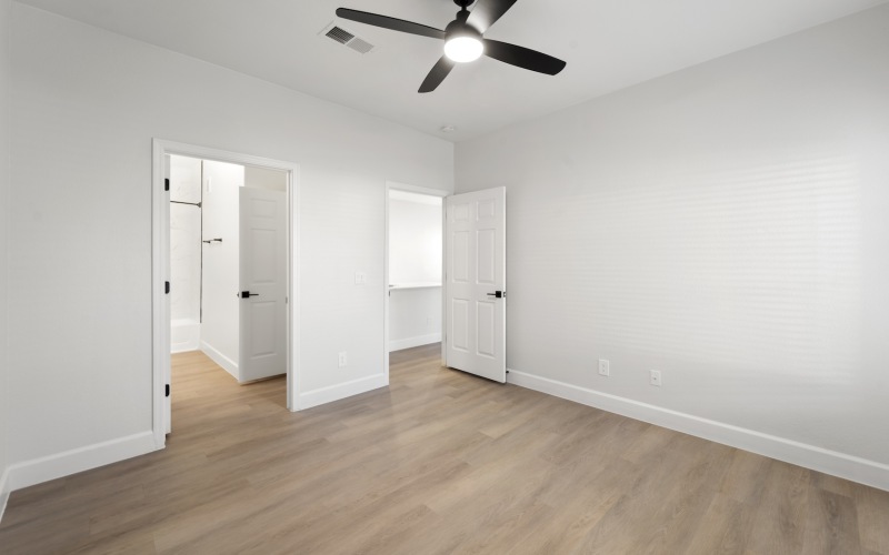 a spacious bedroom with faux-wood floors